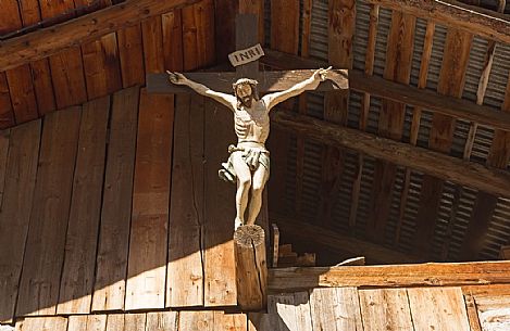 Crucifix hanging on a barn in Dosoledo, Comelico Superiore, dolomites, Italy