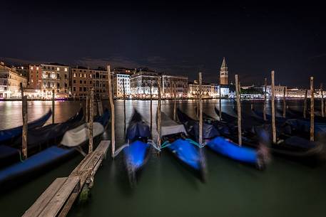 Gondolas moored by night, in the background the Campanile San Marco bell tower and the historical palaces of Venice, Venice, Veneto, Italy, Europe