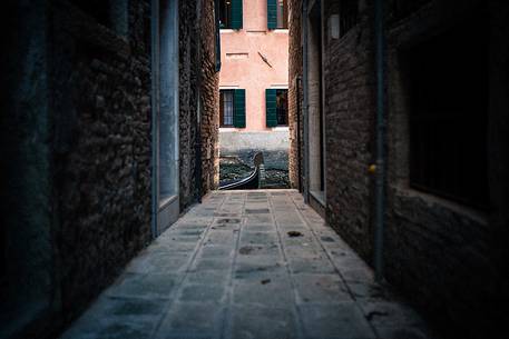 Detail of gondola on the canal from a dark calle, Venice, Italy, Europe