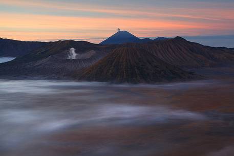 A primordial sunrise of smoking volcanoes of Bromo Tengger Semeru National Park, Isle of Java.