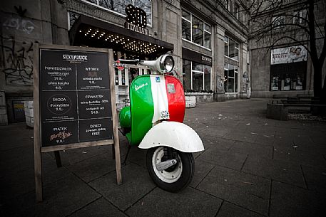 Vespa, vintage scooter stands in an alley of Warsaw, Poland