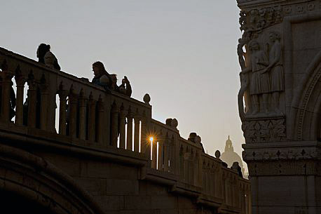 Tourists admire the ducal palace Palazo Ducale from the Straw bridge in Venice, in the distance the dome of the basilica di Santa Maria della Salute. Italy