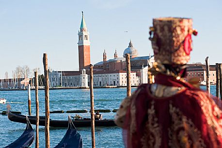 A carnival mask in Venice looking San Giorgio Maggiore from Piazza San Marco square, Venice, Italy, Europe