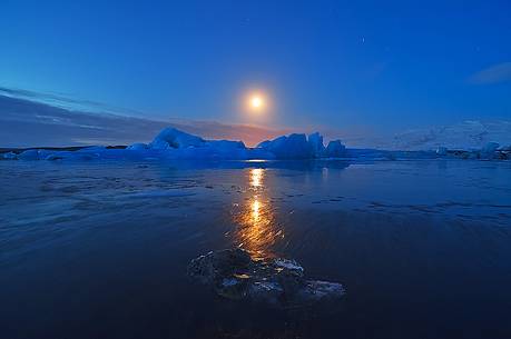 The moon reflecting on the frozen lagoon enriches the landscape with magic.