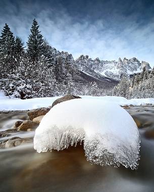 Snow covered boulder with Giaf Valley in the background