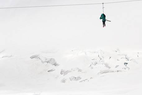 Fun on Aletsch glacier, floating on the steel cable over crevasses, Jungfraujoch, Berner Oberland, Switzerland, Europe