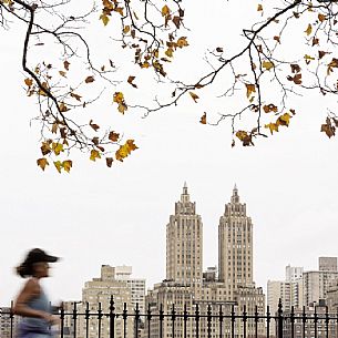 Woman running by the Jaqueline Kennedy Onassis Reservoir with El Dorado Apartments building in the background