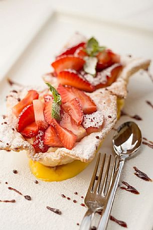 Short pastry basket with strawberries and custard at restaurant Skay of Comelico Superiore, Cadore, Italy