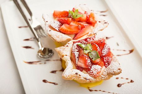 Short pastry basket with strawberries and custard at restaurant Skay of Comelico Superiore, Cadore, Italy