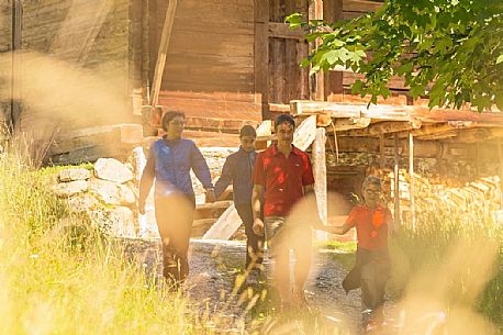 Family walking between the huts of Val Visdende, Comelico, Italy
