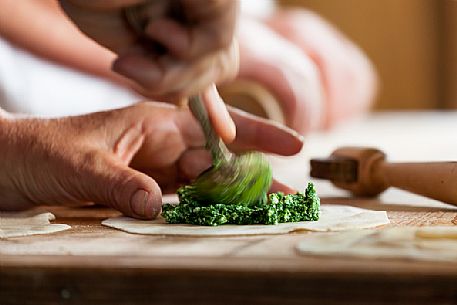 Preparation of traditional turtres (pancakes stuffed with cheese and spinach) at the Segra da Paur festival, La Val, Val Badia