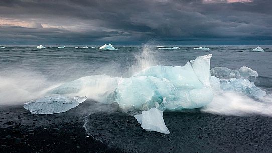 Blue iceberg on black volcanic beach, Jokulsarlon lagoon, Iceland