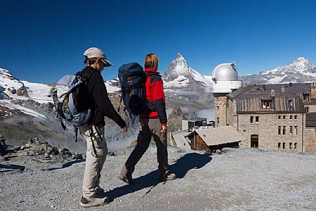 Hikers at the Gornergrat, in the background the Matterhorn or Cervino mount and the Kulm hotel with the astronomic observatory, Zermatt, Valais, Switzerland, Europe
