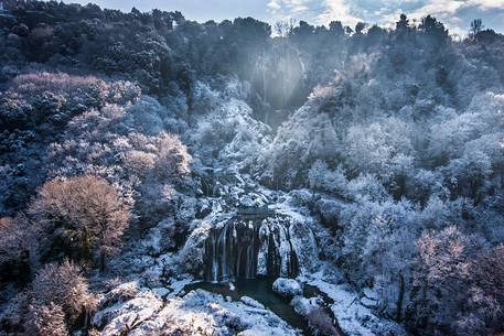 The Marmore waterfall in winter, surrounded by woods with ice and galaverna
