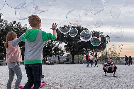 A street artist make soap bubbles for children in Pincio's terrace.