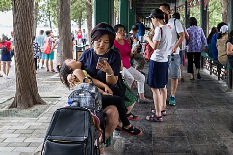 People resting below the Long Corridor inside the Summer Palace in Beijing