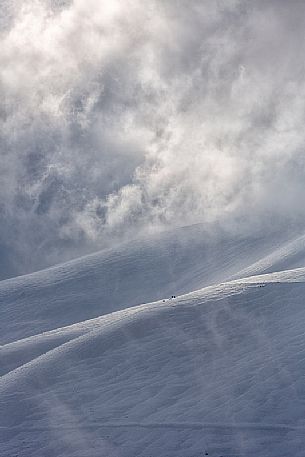 The magic of the light that filters through the rising fog makes the magical landscape of Castelluccio, Sibillini national park, Umbria, Italy, Europe