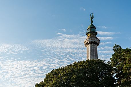 Vision among the trees, lighthouse of Victory, or Faro della Vittoria, National Monument in  Trieste, Friuli Venezia Giulia, Italy, Europe