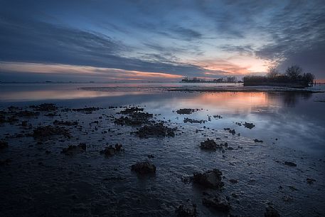 Muddy water and traditional village in Grado lagoon, Friuli Venezia Giulia, Italy