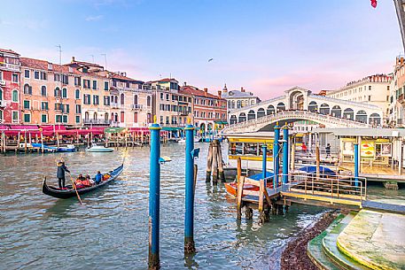 Gondola tourists in the  Canal Grande near Rialto Bridge, Ponte di Rialto in the background at sunset, Venice, Italy, Europe